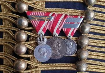 Ein Bild, das Modeaccessoire, Medaille, Metall enthält.
Automatisch generierte Beschreibung