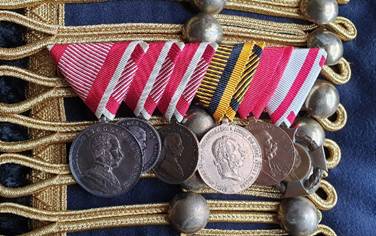 Ein Bild, das Modeaccessoire, Medaille enthält.
Automatisch generierte Beschreibung